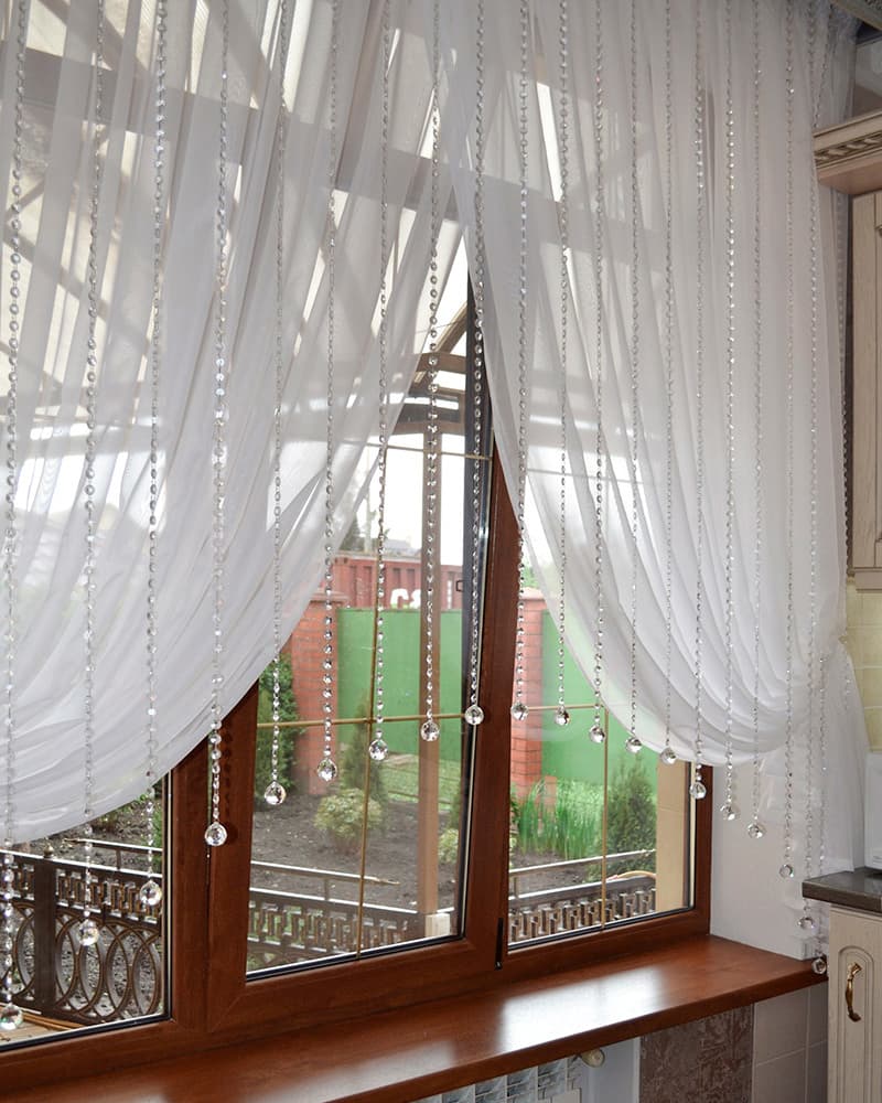 Шторы с декоративными элементами: изысканное дополнение к интерьеру кухни